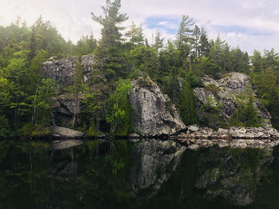 Escarpement rocheux couvert de coniferes en bordure du lac Saint-Pierre