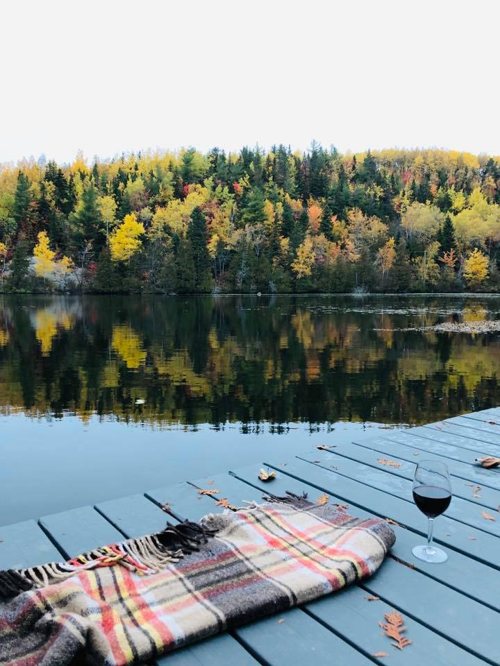 Scène automnale sur un quai du lac avec couverture et verre de vin